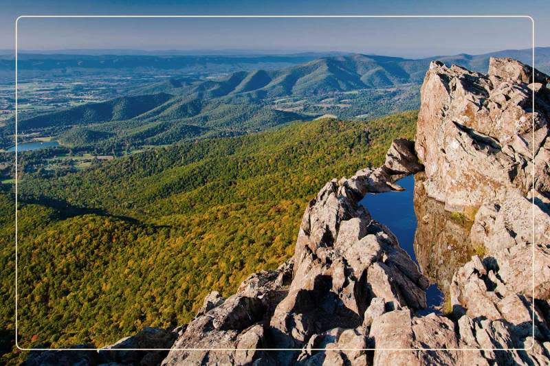 a cliffside view of green rolling hills at Shenandoah National Park, a dog-friendly national park where one can go hiking with dogs